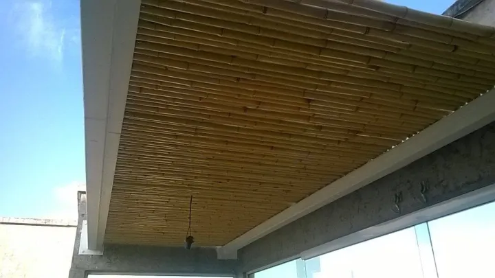 Forro de varas finas de bambu instalado sob uma cobertura metálica branca